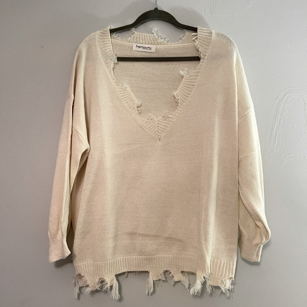 Distressed cream sweater